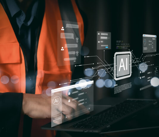 Tecnico con gilet di sicurezza che utilizza un laptop con interfacce di intelligenza artificiale per l'automazione dei processi amministrativi e la riconciliazione bancaria