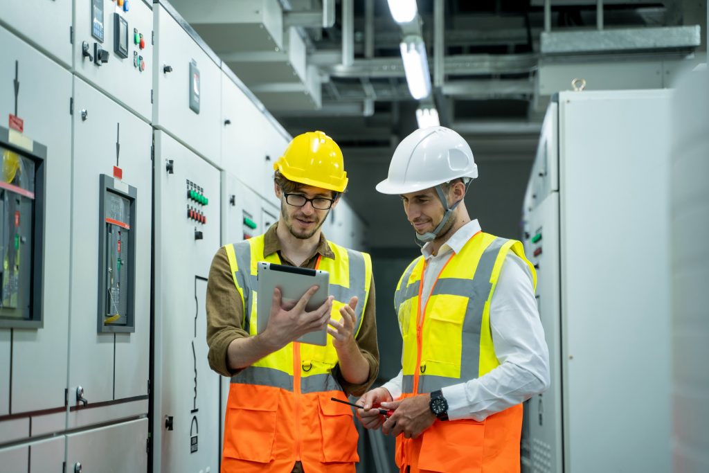 Tecnici elettrici in cantiere consultano un tablet per la gestione amministrativa degli impianti elettrici con software in cloud