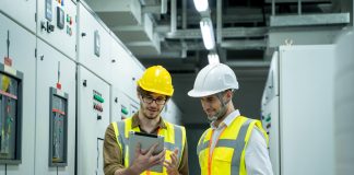 Tecnici elettrici in cantiere consultano un tablet per la gestione amministrativa degli impianti elettrici con software in cloud