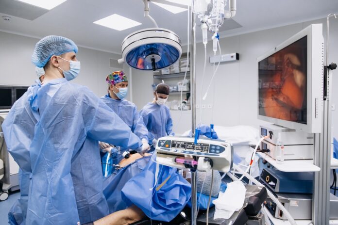 A group of medical surgeons in the operating room during an operation. A patient on the operating table during laparoscopic abdominal surgery. The concept of modern medical equipment.