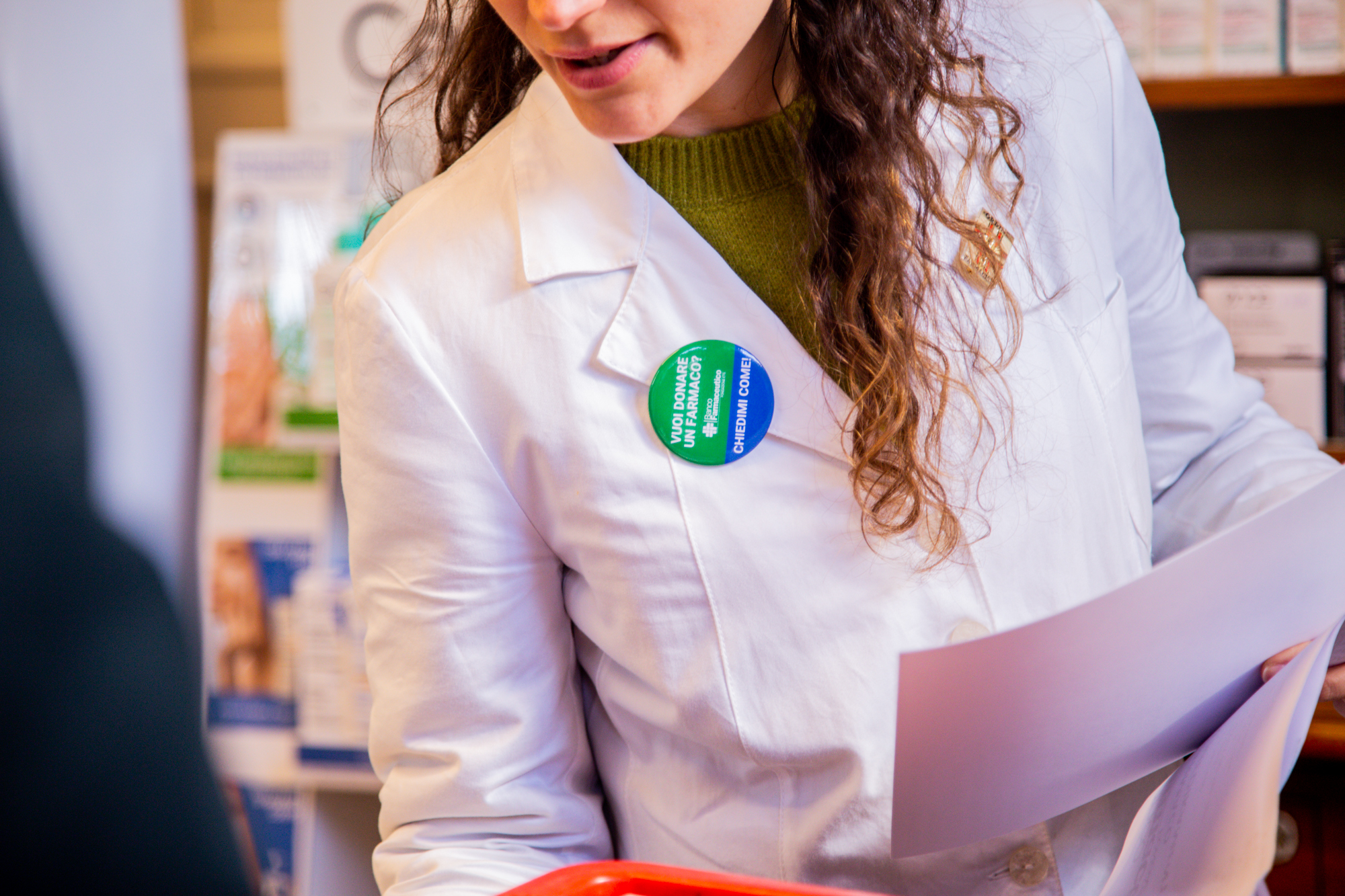 Farmacista con la spilla delle Giornate di Raccolta del Farmaco in farmacia