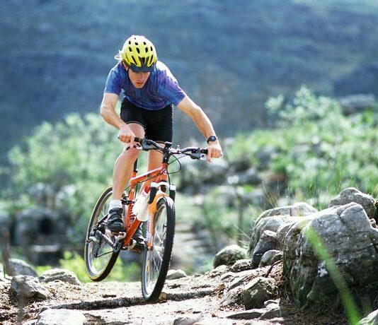 La nutrizione sportiva 2.0: proteine probiotici e vitamina D Ciclista in mountain bike durante un allenamento ad alta intensità in un percorso sterrato
