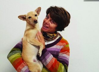 Benessere del cane: comprendere comportamento, alimentazione e integrazione Sabrina Giussani, Medico Veterinario Esperto in Comportamento Animale, tiene in braccio un cane, mostrando attenzione e cura.