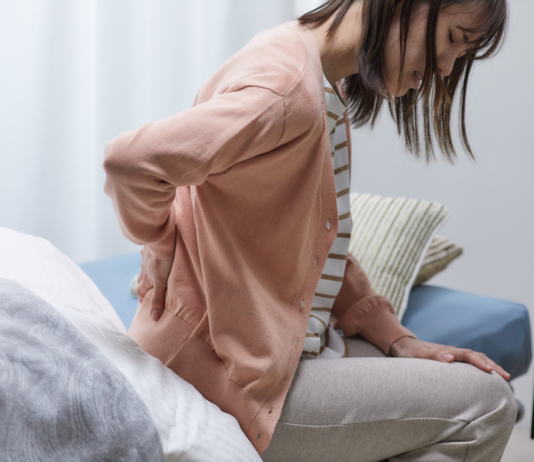 Mal di schiena, cervicalgia e artrosi: una guida al dolore muscolo-scheletrico Donna con dolore alla parte bassa della schiena che si tiene la zona lombare