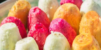 Ficodindia dell’Etna DOP di diverse varietà (gialla, rossa e bianca) sbucciati, esposti in primo piano, con sfondo sfocato dei frutti vulcanici di O.P. La Deliziosa
