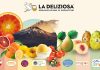 Assortimento di eccellenze ortofrutticole siciliane OP La Deliziosa: Arance Rosse IGP, Fichi d&rsquo;India dell&rsquo;Etna DOP, Pere Coscia e Pesche IGP con lo sfondo del vulcano Etna