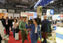 È “veg revolution”: TUTTOFOOD esplora le soluzioni vegetali evolute e premia i reparti europei del fresco Interno dei padiglioni di TUTTOFOOD 2026 a Rho Fieramilano con visitatori tra gli stand e hostess che sorregge il cartello ufficiale della manifestazione