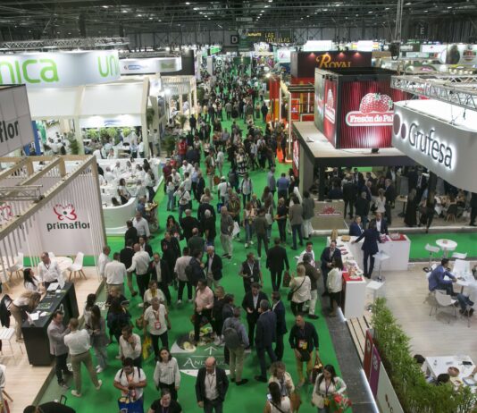 Veduta dall'alto dei padiglioni affollati della fiera dell'ortofrutta Fruit Attraction con visitatori, stand aziendali ed espositori del settore agricolo