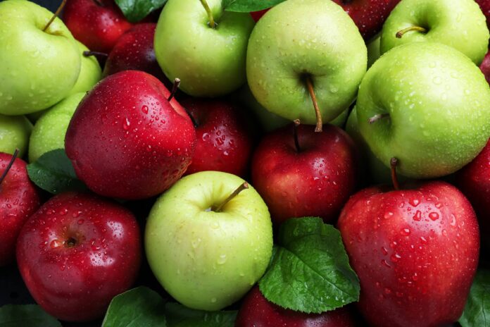 Fresh ripe green and red apples with water drops as background, top view mele