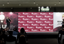 Luv Fiera 2026, registrazioni aperte per l’appuntamento di Bari Un oratore parla dal podio durante una conferenza ufficiale a LUV Fiera dell'uva da tavola a Bari, con un grande fondale brandizzato e il logo della Regione Puglia sullo sfondo, davanti a una platea di operatori del settore