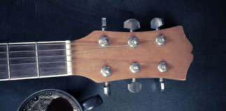 Coffee and guitar on wooden table. (Vintage Style)