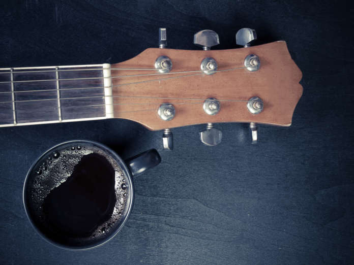 Coffee and guitar on wooden table. (Vintage Style)