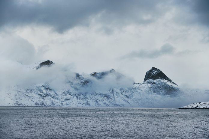 Paesaggio invernale della costa norvegese con montagne innevate e mare grigio, simbolo dell’origine naturale e incontaminata dei prodotti ittici norvegesi promossi a TuttoFood.