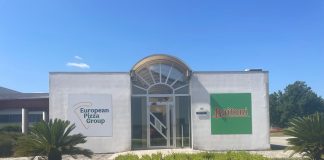 Facciata dello stabilimento European Pizza Group a Benevento con i loghi Buitoni e European Pizza Group su pareti bianche, prato e piante in primo piano, a simboleggiare il progetto di gestione scarti di produzione