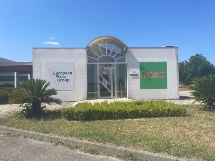 Facciata dello stabilimento European Pizza Group a Benevento con i loghi Buitoni e European Pizza Group su pareti bianche, prato e piante in primo piano, a simboleggiare il progetto di gestione scarti di produzione