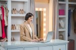Il caso Saks e il declino dei department store Usa. Quali insegnamenti per l’Italia Titolare di negozio di abbigliamento gestisce il punto vendita da laptop, semplificando la gestione del negozio con strumenti digitali