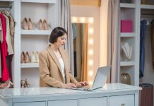 Titolare di negozio di abbigliamento gestisce il punto vendita da laptop, semplificando la gestione del negozio con strumenti digitali