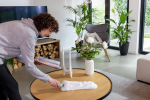 Superduster è il nuovo spolveratore ecologico per superfici e pavimenti Donna sorridente pulisce un tavolino da caffè con Leifheit Superduster, lo spolveratore a mano ecologico per la rimozione polvere sostenibile