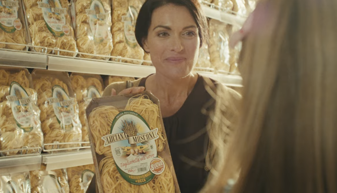 Luciana Mosconi torna in TV: sonna con confezione di tagliatelle Luciana Mosconi in supermercato, scena dallo spot TV della nuova campagna pubblicitaria