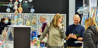 Visitatori agli stand di Quick&More esaminano articoli da regalo, souvenir e decorazioni durante la fiera B2B a Fieramilano