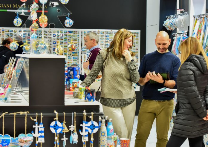 Visitatori agli stand di Quick&More esaminano articoli da regalo, souvenir e decorazioni durante la fiera B2B a Fieramilano