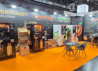 Stand fieristico di Oranfresh a Euroshop 2026 con pavimentazione arancione, macchine per spremute fresche, espositori di arance e tavoli da bar