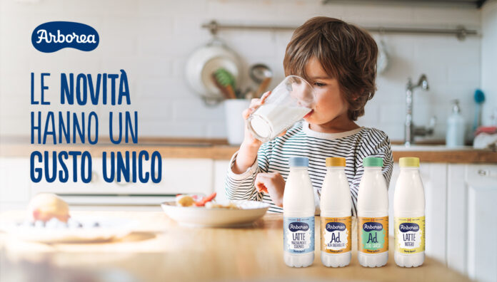 Bambino che beve un bicchiere di latte e gamma di bottiglie rPet Latte Arborea presentate a Tuttofood 2026, con logo e payoff 