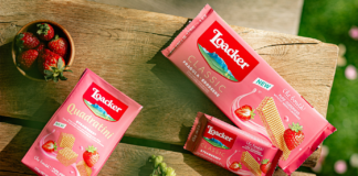 Confezioni dei nuovi wafer Loacker Strawberry (Classic e Quadratini) esposte su un tavolo di legno all'aperto con fragole fresche, novità presentata a Tuttofood 2026