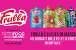 Banner pubblicitario Frullà per Tuttofood 2026 a Milano: il brand di Natura Nuova si presenta a Fieramilano (Pad. 4 - Stand G08) come leader di marca nel mercato delle polpe di frutta in doypack. L'immagine mostra i gusti Mela Fragola Mirtilli, Biologico Mela Pesca Mango e 100% Ananas