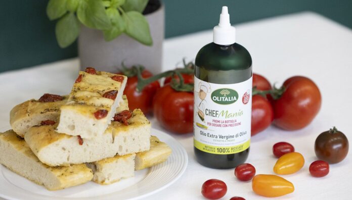 Bottiglia squeezable di olio extravergine di oliva Olitalia CHEFMania accanto a tranci di focac-cia e pomodori freschi, innovazione retail presentata a Tuttofood 2026