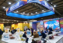 La nuova era dello yogurt greco altoproteico Stand espositivo Neogal a Tuttofood 2026 per il lancio del nuovo yogurt greco altoproteico con grafiche promozionali della linea e visitatori ai tavoli