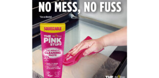 Il nuovo formato in tubo squeezable di The Pink Stuff Miracle Cleaning Paste utilizzato per la pulizia del vetro di un forno con un panno rosa