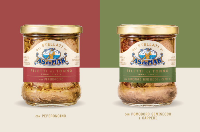 Gli Stellati AsDoMar 2026 Due vasi di vetro della linea Gli Stellati AsDoMar mostrano i filetti di tonno premium in olio d'oliva: a sinistra la referenza con peperoncino, a destra quella con pomodoro semisecco di Sardegna e capperi, entrambi con packaging trasparente e tappo color oro