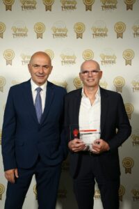 Antonio Giovanetti e Gianfranco Delfini di CLAI mostrano il premio New Entry vinto dalla linea Fragranze di Salame CLAI ai Brands Award 2026, posando davanti al wall ufficiale dell'evento