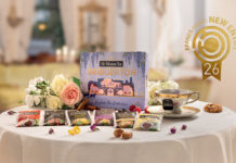 Pompadour vince il Brands Award con il tè ispirato alla serie Bridgerton Confezione regalo e bustine assortite della linea Sir Winston Tea Bridgerton di Pompadour su un tavolo imbandito, con logo dorato Brands Award New Entry 26 in alto a destra