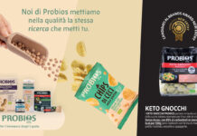 Una panoramica dei prodotti Probios esposti su uno sfondo grafico che mette in evidenza la qualità degli ingredienti biologici. A sinistra, diverse referenze tra cui pane, biscotti, succhi e una mano che versa ceci da un mestolo di legno. Al centro, una confezione di Chips di Ceci Probios aperta con chips sparse. A destra, in evidenza, la confezione di Keto Gnocchi Probios con il logo Brands Award New Entry 2026 e la descrizione dei benefici nutrizionali per uno stile di vita low carb