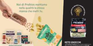 Una panoramica dei prodotti Probios esposti su uno sfondo grafico che mette in evidenza la qualità degli ingredienti biologici. A sinistra, diverse referenze tra cui pane, biscotti, succhi e una mano che versa ceci da un mestolo di legno. Al centro, una confezione di Chips di Ceci Probios aperta con chips sparse. A destra, in evidenza, la confezione di Keto Gnocchi Probios con il logo Brands Award New Entry 2026 e la descrizione dei benefici nutrizionali per uno stile di vita low carb