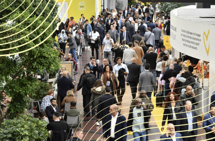 Sial Parigi Affollato corridoio della fiera SIAL 2026 a Parigi, con professionisti, buyer del largo consumo e stand espositivi del settore agroalimentare