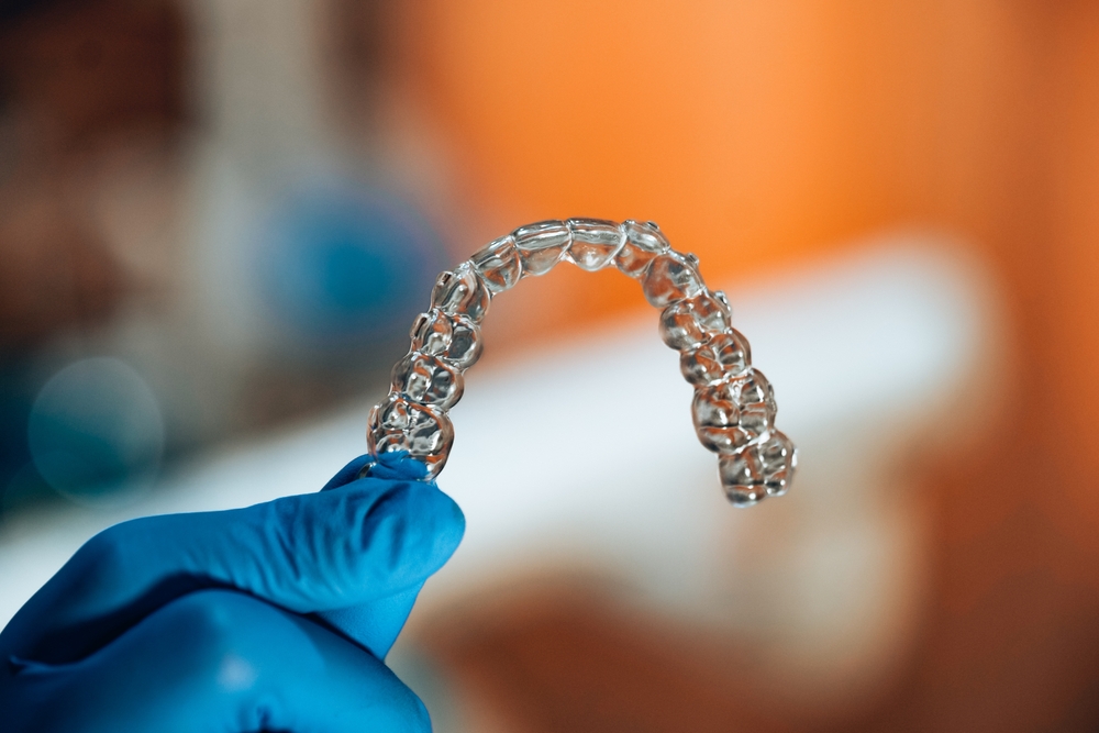 A,Dental,Nurse,With,Blue,Gloves,,Holding,An,Aligner,Which rivestimento antibatterico