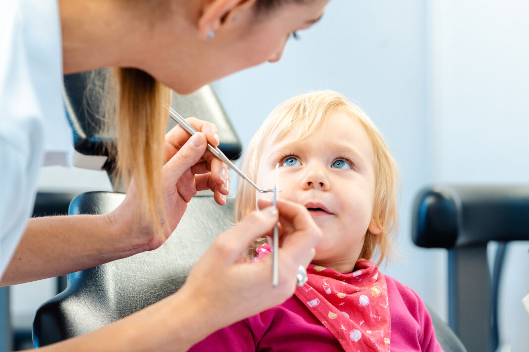 Dentist explaining treatment to a child using a plush toy Pensiero creativo