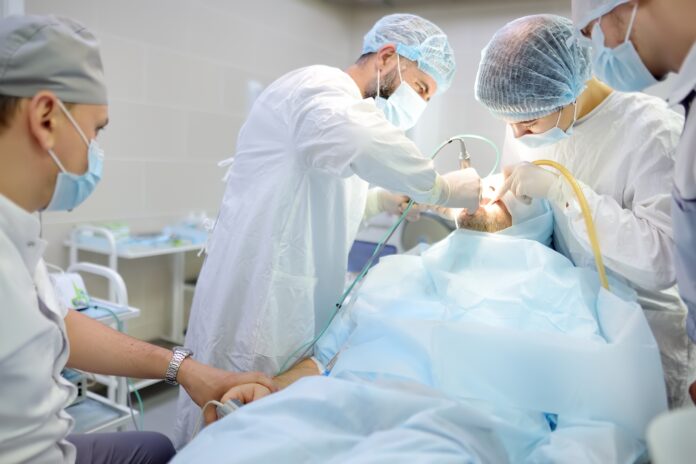 Surgeon,And,Nurse,During,A,Dental,Operation.anesthetized,Patient,In,The Rialzo del seno transcrestale