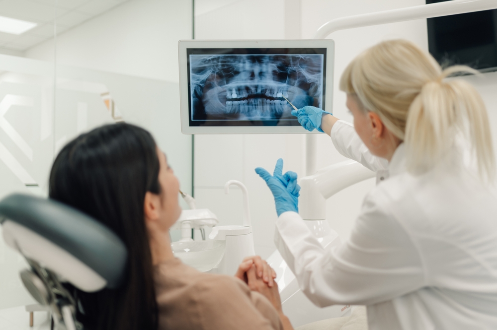 Female,Dentist,Pointing,At,Digital,X,Ray,Image,On,Computer Diagnosi severe