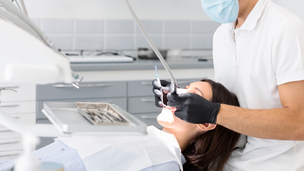 Young,Dentist,Doctor,In,Glasses,Filling,Teeth,To,Female,Patient, materiali da restauro