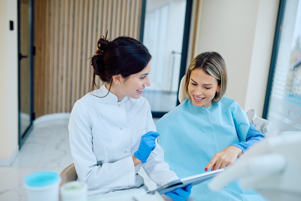 Female,Dentist,Discussing,Treatment,Plan,With,A,Smiling,Patient,Wearing Etica odontoiatrica