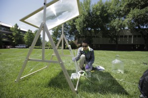 SEMPLICE, ECONOMICO, EFFICACE. I prototipi sono studiati per essere utilizzati nei paesi in via di sviluppo. Nell'immagine, Paul Shen al lavoro con una lente fresnel montata su un supporto in legno e con un contenitore in materiale trasparente permeabile ai raggi UV. Uno dei prossimi passi della sperimentazione consosterà nell'uso di batteri patogeni.(FOTO Prof. Ernest R. Blatchley III)