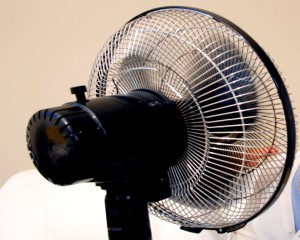 Frau kühlt sich mit einem Ventilator ab Woman with Hot F lushes Model-Released