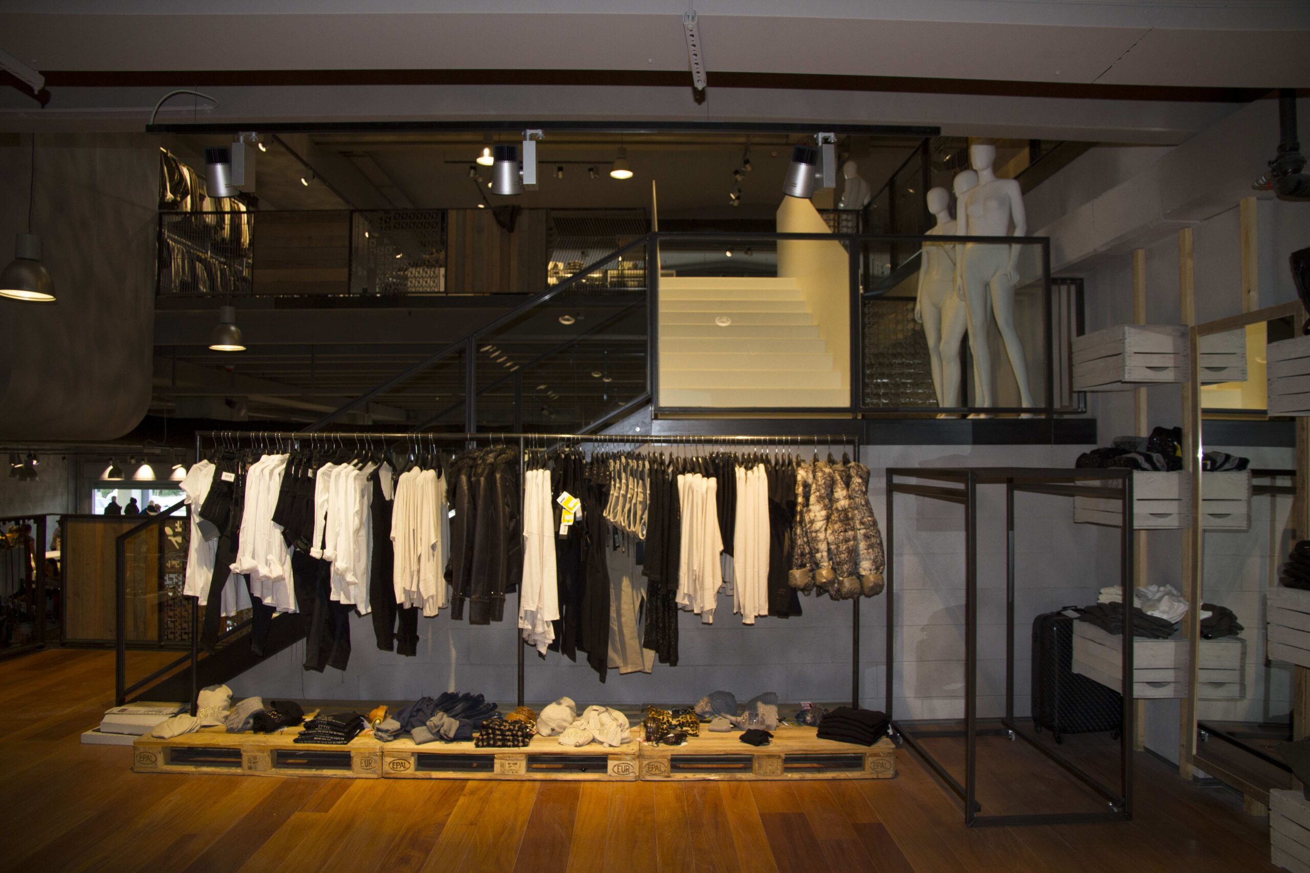 Anche se il negozio vuole offrire un'immagine “industriale”, non si voleva rischiare di appiattire lo spazio con la classica illuminazione in fila continua. Si è preferita una soluzione flessibile ma ad effetto, con binari e proiettori