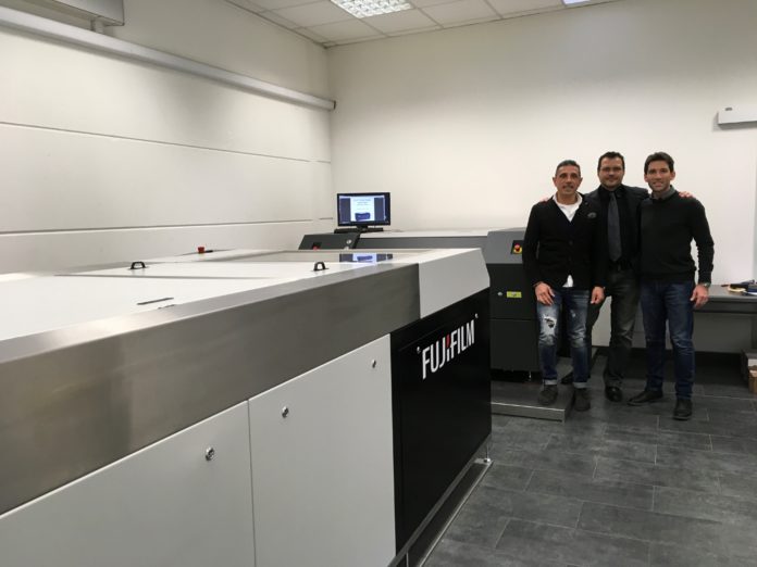 Fufi-Flexostudio Fiorenzo Fenu, Denny Loi di Flexostudio insieme a Claudio Giacomelli di Synergic Solution davanti alla S928 di Fujifilm e al CDI 4835 di Esko.