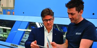 Con una terza linea di brossura Corona C15, Rotolito Lombarda migliora i processi produttivi Il direttore della legatoria Matteo Quadri (a destra) mostra a Fabio Casale di Müller Martini Italia un catalogo appena brossurato sulla Corona.