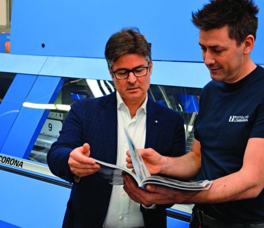 Con una terza linea di brossura Corona C15, Rotolito Lombarda migliora i processi produttivi Il direttore della legatoria Matteo Quadri (a destra) mostra a Fabio Casale di Müller Martini Italia un catalogo appena brossurato sulla Corona.